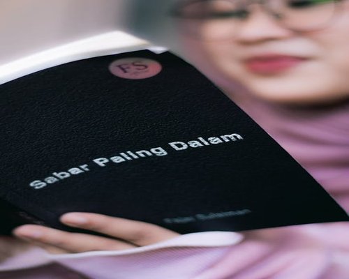 Seorang membaca buku di ruang yang tenang